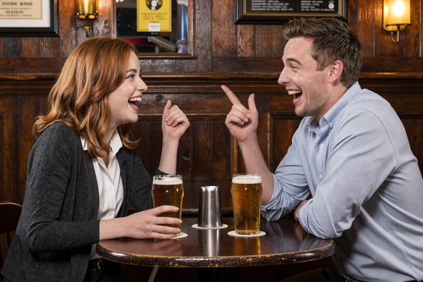 British couple enjoying witty pub date with banter and laughter in traditional cozy pub setting